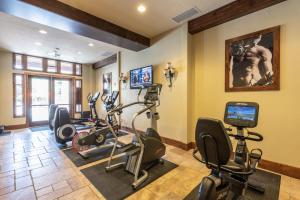 a gym with several exercise bikes and a television at Luxury Amenities and Resort Ski In Ski Out Pool Hyatt Double Queen Hotel Room in Park City