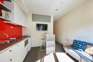 eine Küche mit einem Waschbecken und einem Sofa in einem Zimmer in der Unterkunft ReadySet Apartments at Kett in Melbourne