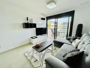 a living room with a couch and a tv at Playa Flamenca in Orihuela Costa