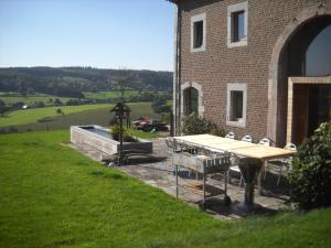 a picnic table in front of a brick building at À la Belle Vue in Limbourg