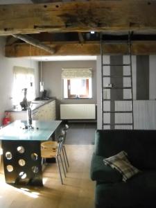 een keuken en een woonkamer met een bank en een tafel bij À la Belle Vue in Limbourg