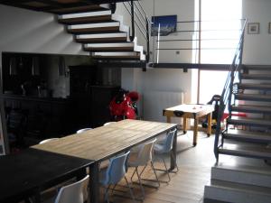 ein Esszimmer mit einem Tisch mit Stühlen und einer Treppe in der Unterkunft À la Belle Vue in Limbourg