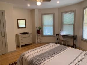 a bedroom with a bed and a desk and windows at 125-#4 Downtown cozy upstairs one bedroom apt in San Antonio