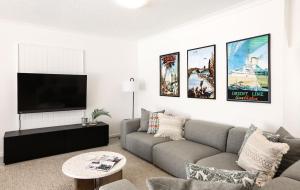 a living room with a couch and a flat screen tv at Portofino 2 in Noosa Heads