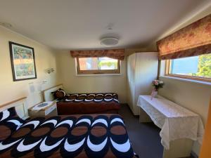 Habitación pequeña con 2 camas y mesa. en Villa Meri Apartments, en Pärnu