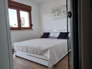 a bedroom with a white bed with blue pillows at Angel wing apartmant in Duće