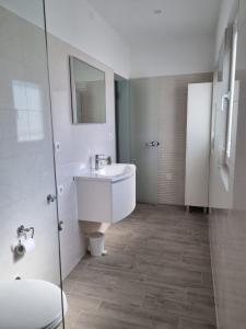 a white bathroom with a sink and a mirror at Angel wing apartmant in Duće +13 photos