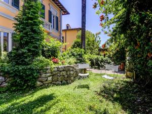 a yard with two chairs and a stone wall at Belvilla by OYO Villa Lazzarino in Pisa