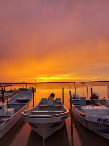 a group of boats docked at a dock at sunset at Casa Ka'an Rio. in Río Lagartos