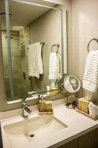 baño con lavabo y espejo grande en JF Apartments en Tegucigalpa