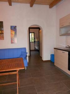 Il comprend un salon avec un canapé bleu et une cuisine. dans l'établissement Case vacanza vicino al mare, à Parghelia