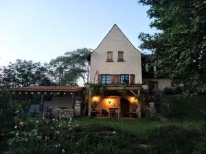 a large white house with a porch with lights at AU SOLEIL COUCHANT in Saint-Julien-de-Lampon