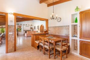 a kitchen and dining room with a table and chairs at Villa Emazabel in Pollença