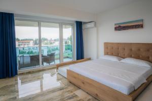 - une chambre avec un lit et une grande fenêtre dans l'établissement HOME for FOUR, à Mamaia Nord – Năvodari