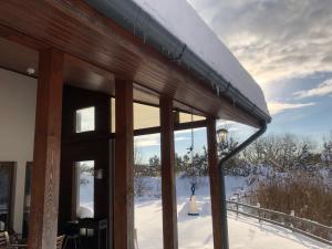un edificio con techo cubierto de nieve y ventanas en Holiday House Koceri en Ķekava