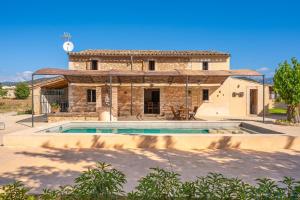 a house with a swimming pool in front of it at Es Verger in Binissalem