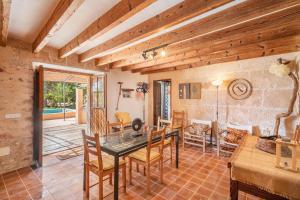 a dining room with a table and chairs and a living room at Es Verger in Binissalem