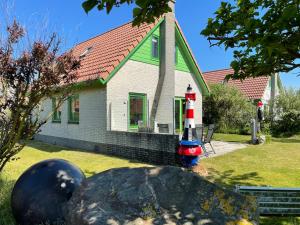 dom z latarnią morską na skale w ogrodzie w obiekcie Bungalow Strandparel w mieście Julianadorp