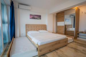 a bedroom with a large bed and a mirror at HOME FOR SEVEN in Mamaia Sat/Năvodari