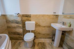 a bathroom with a toilet and a sink at HOME FOR SEVEN in Mamaia Sat/Năvodari +17 photos