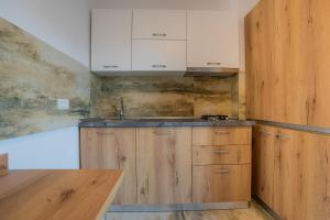a kitchen with wooden cabinets and a sink at HOME FOR SEVEN in Mamaia Nord