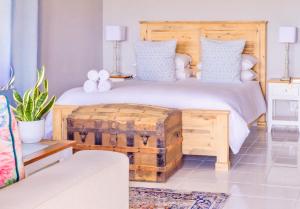 a bedroom with a large bed with a wooden headboard at River Front Estate in Addo