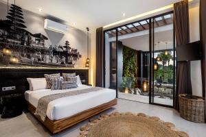 a bedroom with a bed and a large window at Villa Australis in Kerobokan