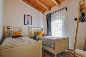 - une chambre avec 2 lits et une fenêtre dans l'établissement Lovely Istrian house - Šegon, à Plomin
