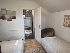 1 dormitorio pequeño con 2 camas y 1 silla en Apartman Majetić en Otočac