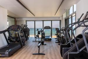 a gym with treadmills and exercise equipment and the ocean at Hôtel & Spa Hélianthal by Thalazur in Saint-Jean-de-Luz