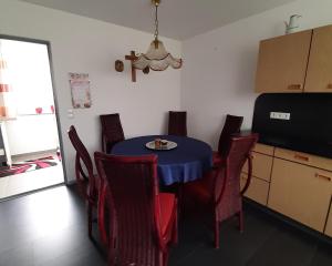 a dining room with a blue table and red chairs at Ferienwohnung Inge in Waldsassen