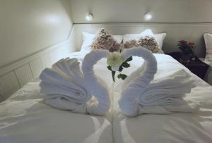 two towels shaped like swans sitting on a bed at Banpim hillside Lofoten with Jacusszi in Gravdal