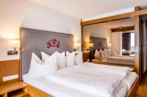 a bedroom with two beds with white pillows at Damülser Hof - Wellness & Spa in Damuls