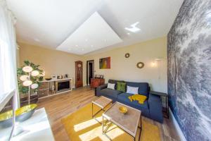 un soggiorno con un divano blu e un tavolo di RétroMirabeau "Le Raspaïl" - 65m2 avec VUE - 2 CHAMBRES - 4 pers - COURS MIRABEAU HALLES GARE - EMPLACEMENT TOP - Chèques Vacances CONNECT a Narbonne