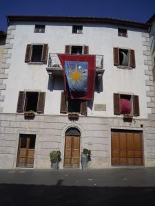 un edificio con una bandera a un lado. en Vedetta Townhouse - camere e appartamenti nel centro storico by Be Vedetta, en Scarlino