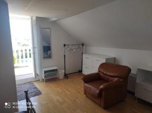 a living room with a leather chair and a window at House Vodice in Vodice