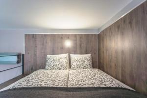 1 dormitorio con 1 cama con pared de madera en Hotel Sissy Residence, en Budapest