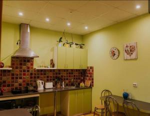 a kitchen with green cabinets and a table with chairs at Guest house Baltika in Ventspils