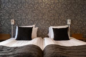 斯卡拉的住宿－Skara Stay & Go，卧室内的两张床和黑色枕头