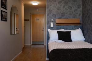 Schlafzimmer mit einem Bett mit einem Kopfteil und einer Tür in der Unterkunft Skara Stay & Go in Skara