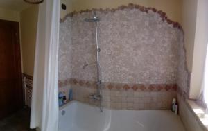 La salle de bains est pourvue d'une baignoire et d'une douche. dans l'établissement B&B IL LEPRICE, à SantʼElpidio a Mare