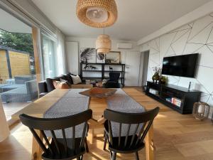 a living room with a table and chairs and a television at Grafit in Mechelinki