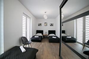 Cette chambre comprend deux lits, une table et des chaises. dans l'établissement Oxygen apartament nr 4, à Mielec