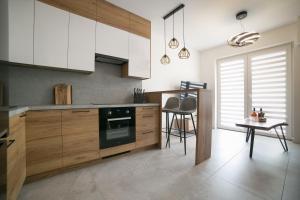 a kitchen with wooden cabinets and a table in it at Oxygen apartament nr 4 in Mielec