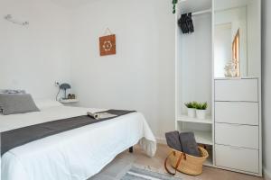 a white bedroom with a bed and a dresser at Sa Marineta in Porto Cristo