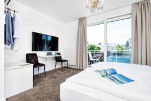 TV a/nebo společenská místnost v ubytování Hotel Velden - 24 Checkin Zimmer im Zentrum