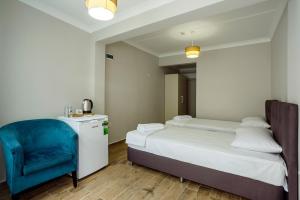 a bedroom with a bed and a blue chair at Vesta Butik Otel in Edremit