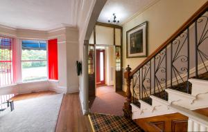 a staircase in a home with a red wall at Homeleigh Hotel in Bradford