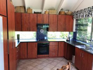 a kitchen with wooden cabinets and a stove top oven at The Gables Guest House in Belfast