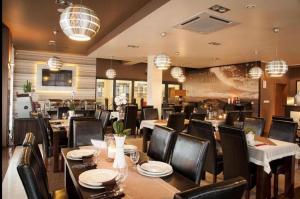 Un comedor con mesas, sillas y candelabros. en Apartament 303 Planeta, en Mielno